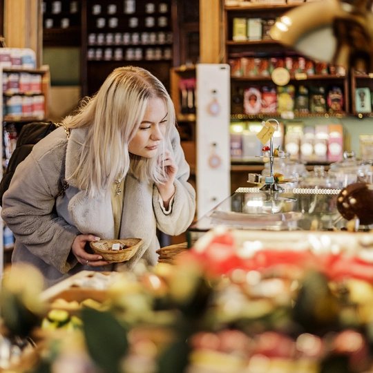Eine junge Frau beim Weihnachtsshopping im Geschäft Winterfeldt Schokoladen in Berlin