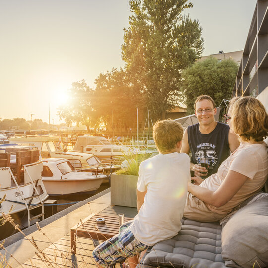 Famiglia che si gode il sole della sera al Rummelsburger See di Berlino