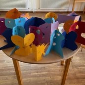 Bunte Scherenschnitte in Form von kleinen Figuren und Gesichtern