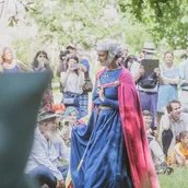 Eine Adlige schreitet im Museumsdorf Düppel durch eine Menschenmenge.