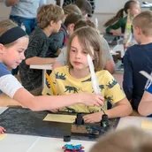 Kinder im Museumslabor schreiben mit Tinte und Feder Kinder im Museumslabor schreiben mit Tinte und Feder