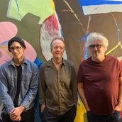 Die Band steht vor einer bunten Wand Die Band steht vor einer bunten Wand