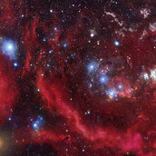 Das Weltall mit rötlichen Nebeln und blauen Sternen