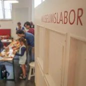 Der Blick ins Museumslabor zeigt eine Gruppe beim Gestalten kreativer Drucke