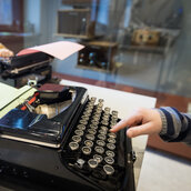 Ein Kind tippt auf einer Schreibmaschine