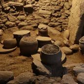 Steingefäße, Platten und Klopfsteine in Fundlage in einem Küchenbereich in Karahantepe, 9400–8000 v.Chr.