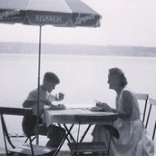 Fotografie von Dirk Kaesler und seiner Mutter unter einem Langnese-Schirm. Historische Fotografie aus Privatbesitz. Fotografie von Dirk Kaesler und seiner Mutter unter einem Langnese-Schirm. Historische Fotografie aus Privatbesitz.