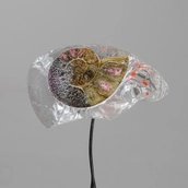 Nahaufnahme einer schneckenförmig geprägten Form aus durchlässigem Kunstharz und anderen Materialien.