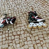 Zwei Inlineskater liegen auf Pflastersteinen