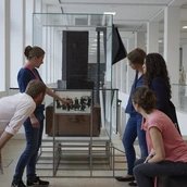 Besucher*innen vor der Geschichte des Ortes Spur 27 "Kunsttransporte ins Exil Wilhelms II"
