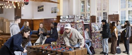 Junge Menschen spielen Tischkicker im Foyer des Three Little Pigs Hotels