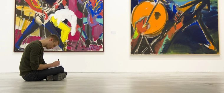 A visitor to the Berlinische Galerie sits on the floor and draws
