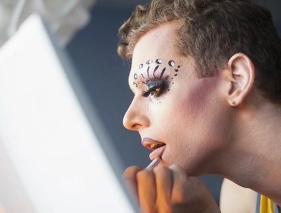 Young man applying drag makeup