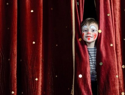 Boy Clown Peering Through Stage Curtains