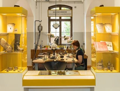 Am Goldschmiedetisch werden die einzelnen Schmuckteile in Handarbeit montiert. Dabei wird gesägt, geschnitten, gebohrt, gefeilt und gelötet.