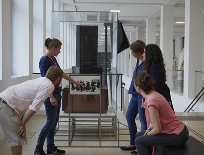 Besucher*innen vor der Geschichte des Ortes Spur 27 "Kunsttransporte ins Exil Wilhelms II"