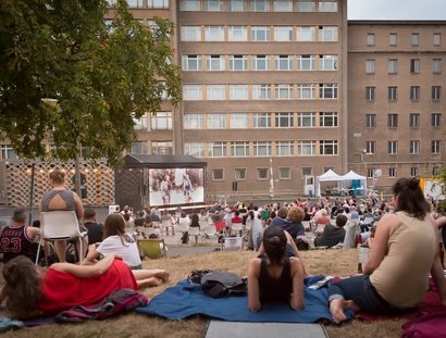 Leinwand vor Haus 1 mit Gästen