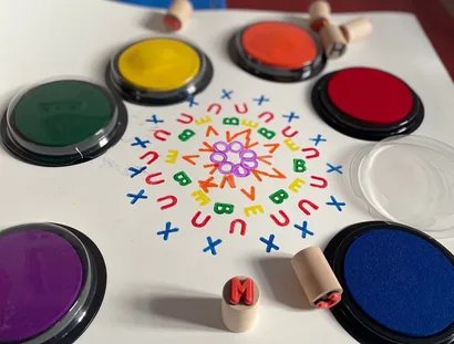 Mit Buchstabenstempeln und Farben entstehen bunte Muster.