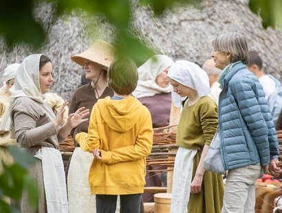 Kommen leicht ins Gespräch: Besucher:innen des Museumsdorf Düppel und Mittelalter-Darsteller:innen.