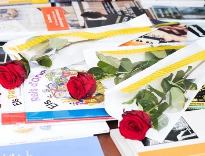 Rosen und Bücher auf einem Tisch liegend
