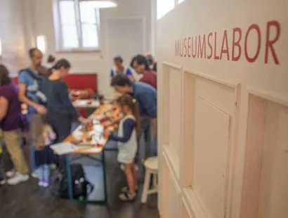 Der Blick ins Museumslabor zeigt eine Gruppe beim Gestalten kreativer Drucke