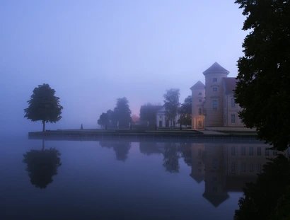 Schloss Rheinsberg in der Dämmerung mit Blick über den See