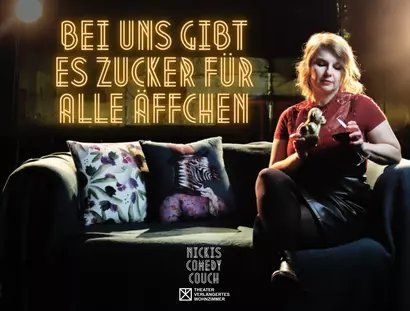 Postkartenmotiv zur Veranstaltung. Im oberen Bereich steht in goldleuchtenden Neonbuchstaben: "Bei uns gibt es Zucker für alle Äffchen". Darunter ein Sofa, auf dem die Gastgeberin Nicki mit einem Glas Rotwein in der Hand sitzt. In der anderen Hand hä