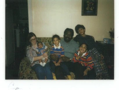 Eltern mit vier Kindern auf einem Sofa