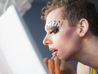 Drag Queen beim Schminken vor dem Spiegel