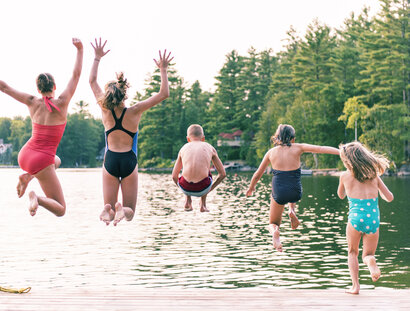 Children jumping into a lake