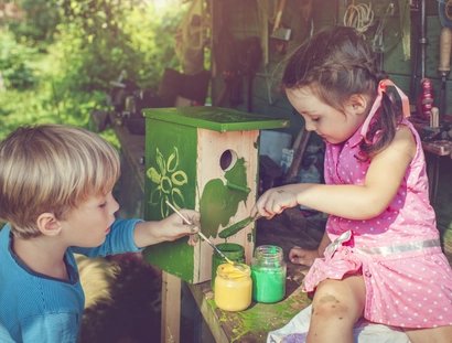 Kinder bemalen Vogelhäuschen