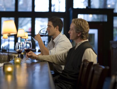 Dos hombres sentados en un bar de Berlín bebiendo vino