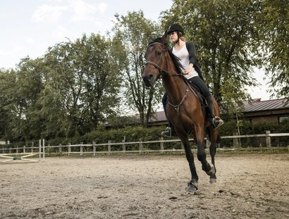 Young woman riding on horse
