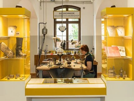 Am Goldschmiedetisch werden die einzelnen Schmuckteile in Handarbeit montiert. Dabei wird gesägt, geschnitten, gebohrt, gefeilt und gelötet.