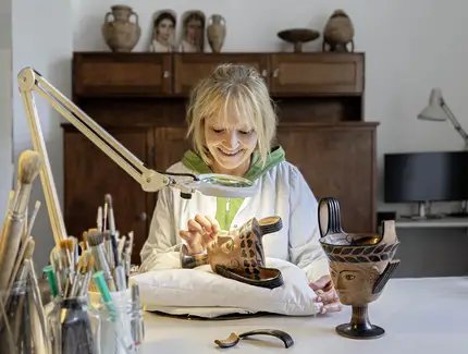 Restauratorin Anke Kobbe bei der Bearbeitung eines Gesichts-Kantharos aus dem 6. Jhd. v. Chr. im Alten Museum.