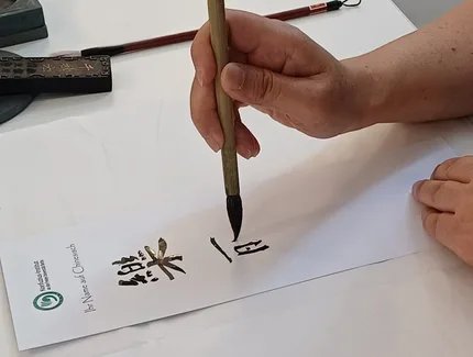 Teilnehmer:innen dieses Mitmach-Angebots können eine chinesische Kalligrafie ihres Namens mit nach Hause nehmen.