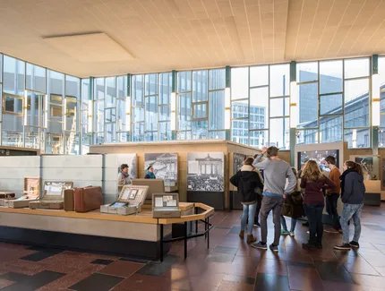 Eine Gruppe von Besuchern steht in der Dauerausstellung im Tränenpalast