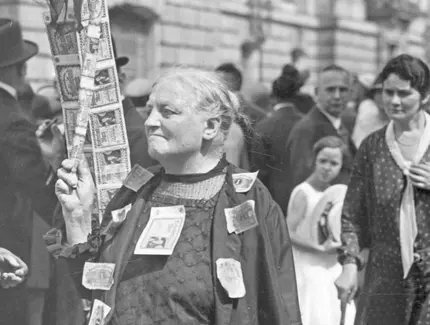Fotografie „Eine Rentnerin protestiert mit aufgenähten Banknoten gegen die Geldentwertung“
