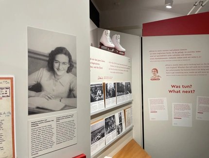 Ausstellungssegment mit historischem Portrait von Margot Frank, Text- und Bildtafeln sowie Schlittschuhen als Ausstellungsobjekt