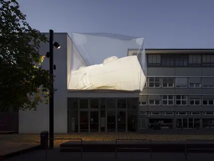 Außenansicht der Berlinischen Galerie bei Abenddämmerung mit einer Installation auf dem Dach