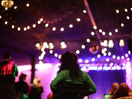 Eine Party im Haus der Berliner Festspiele. Bunte Lichterketten hängen von der Decke.