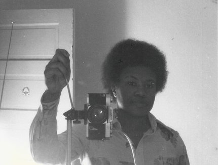 Schwarz-Weiß-Foto von Beverly Buchanan, die ein Selbstporträt im Spiegel macht.