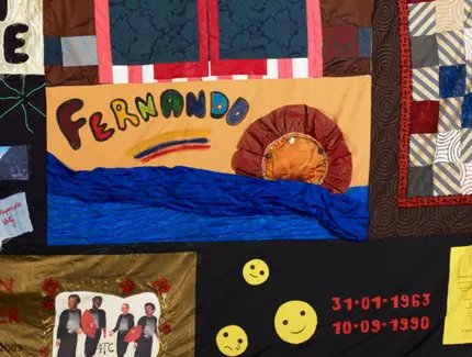 Eine Patch-Work-Decke mit Bildern und Namen von an Aids Verstorbenen.