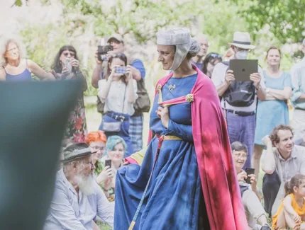 Eine Adlige schreitet im Museumsdorf Düppel durch eine Menschenmenge.