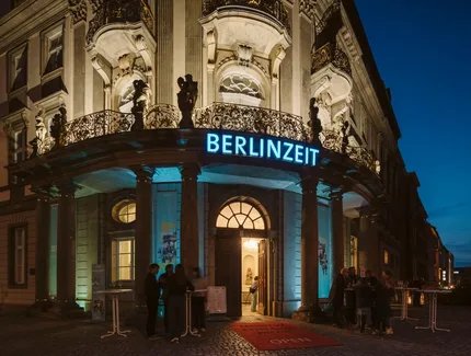 Das Museum bei Nacht von außen mit blauer Leuchtschrift, auf der BERLINZEIT steht