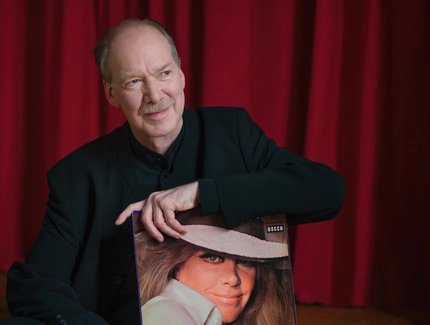Carl Martin Spengler in der Hand ein Schallplattencover mit dem Portrait von Hildegard Knef haltend