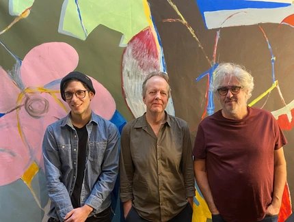 Die Band steht vor einer bunten Wand