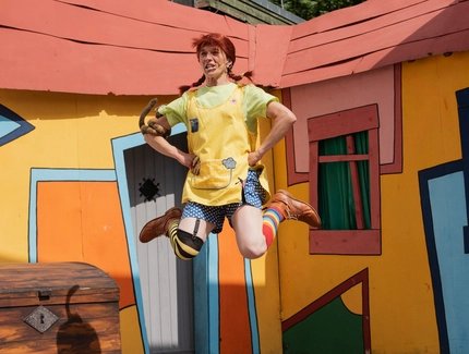 Pippi Langstrumpf springt vor ihrer Villa in die Höhe