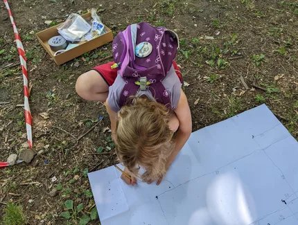 Ein Mädchen zeichnet im äußeren Bereich