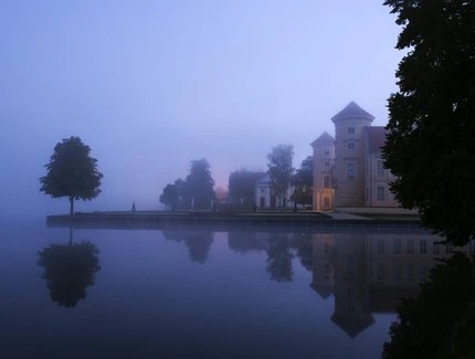 Schloss Rheinsberg in der Dämmerung mit Blick über den See